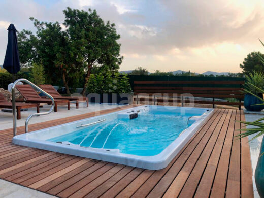 Installation d'un spa de nage privé dans un jardin intégré sur une plate-forme en bois et pierre